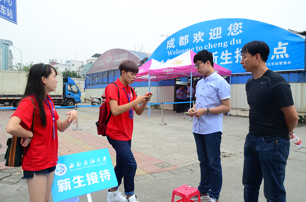 志愿者們?cè)诔啥蓟疖嚤闭具M(jìn)行迎新工作