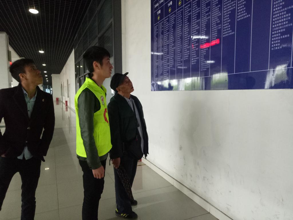 圖4 幫老爺爺查看公交車運行圖的志愿者 圖4 幫老爺爺查看公交車運行圖的志愿者